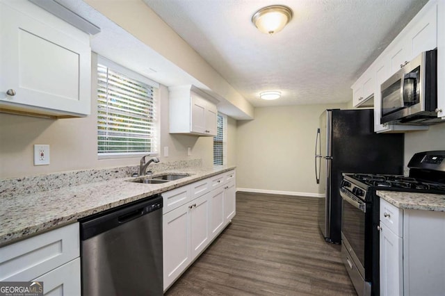 kitchen featuring appliances with stainless steel finishes, white cabinetry, sink, and dark hardwood / wood-style floors