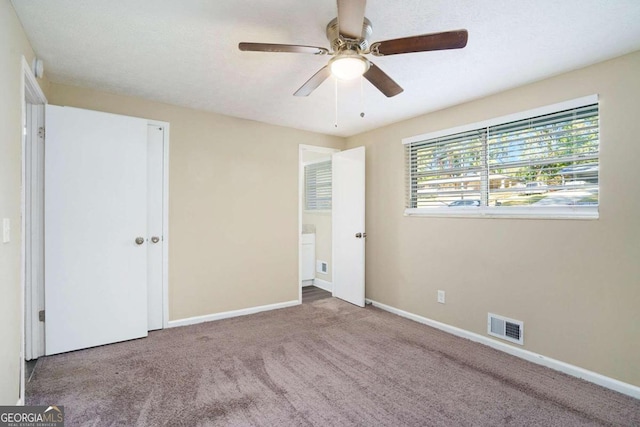 unfurnished room with ceiling fan and carpet