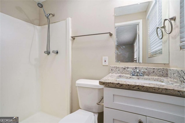 bathroom featuring vanity, toilet, and walk in shower