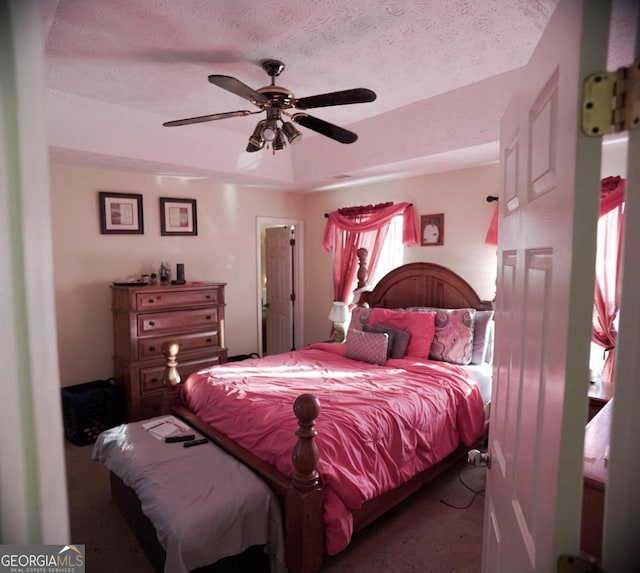 bedroom with a textured ceiling, carpet flooring, and ceiling fan