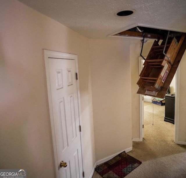 stairs with a textured ceiling and carpet floors