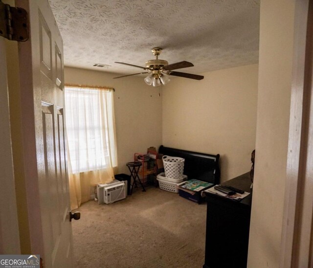 interior space featuring carpet floors, a textured ceiling, and ceiling fan