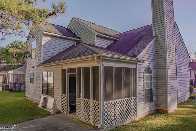 view of property exterior featuring a lawn and a sunroom