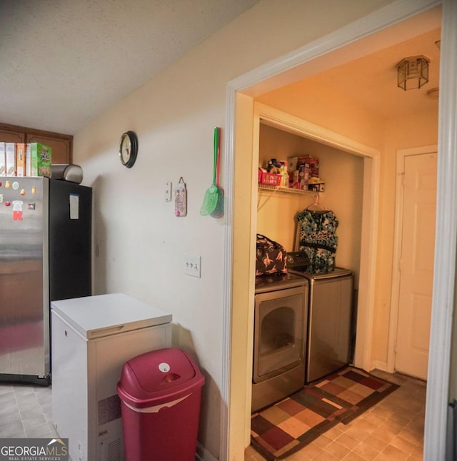 clothes washing area featuring washer and dryer and a textured ceiling