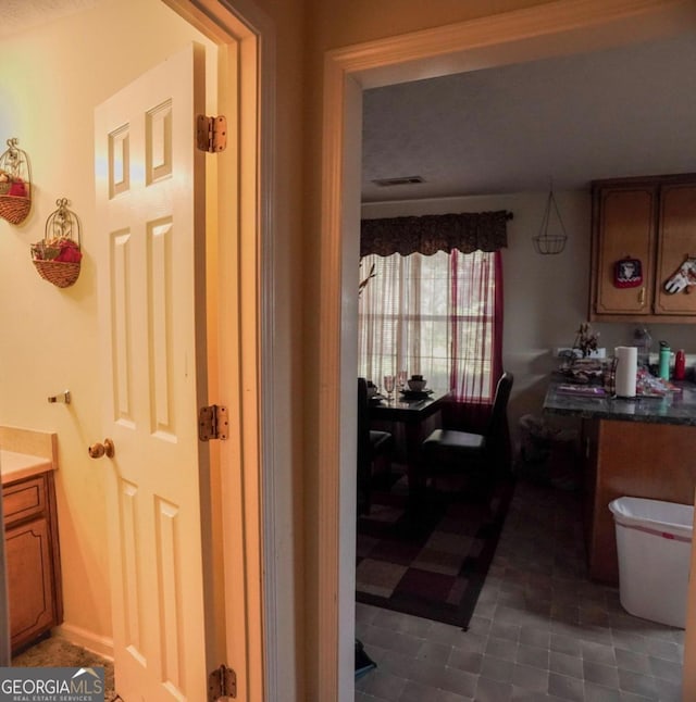 bathroom with toilet, vanity, and tile patterned flooring