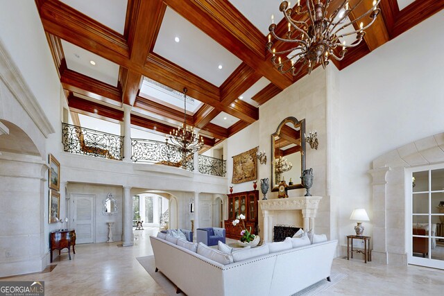 living room featuring beamed ceiling, coffered ceiling, a notable chandelier, and a towering ceiling