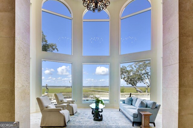 living room featuring a towering ceiling and a notable chandelier