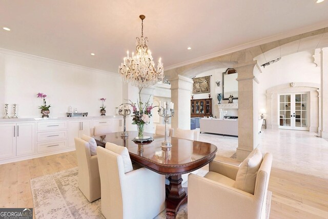 kitchen featuring a large island with sink, premium range hood, light wood-type flooring, range with two ovens, and sink