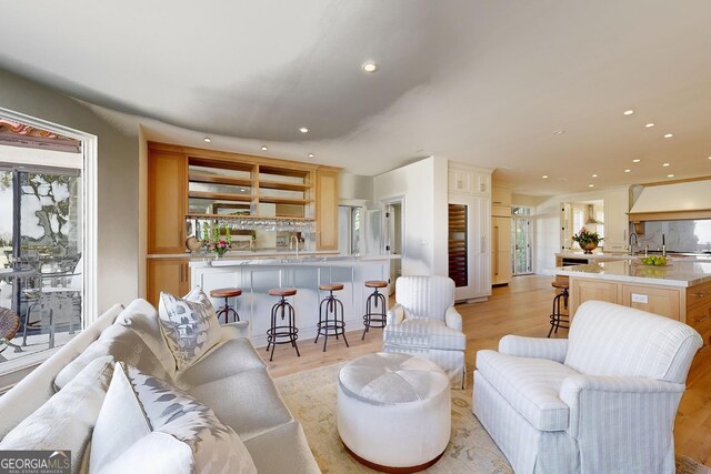 dining space with decorative columns, ornamental molding, and light wood-type flooring