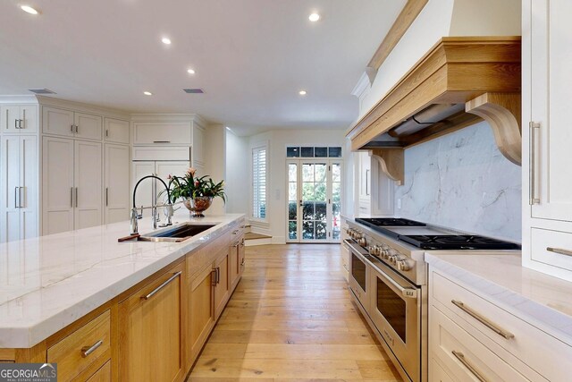 kitchen featuring wall chimney range hood, appliances with stainless steel finishes, wood counters, white cabinetry, and a center island