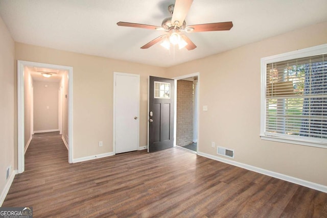 unfurnished bedroom with ceiling fan and dark hardwood / wood-style flooring