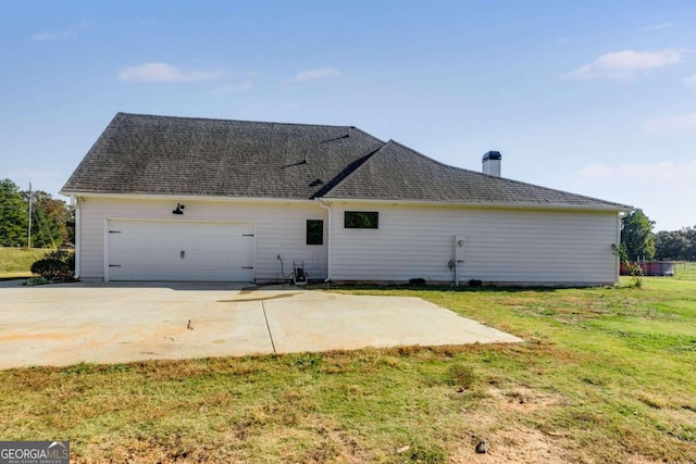 back of property featuring a yard and a garage