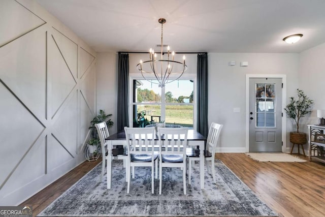 dining space with wood-type flooring and a chandelier