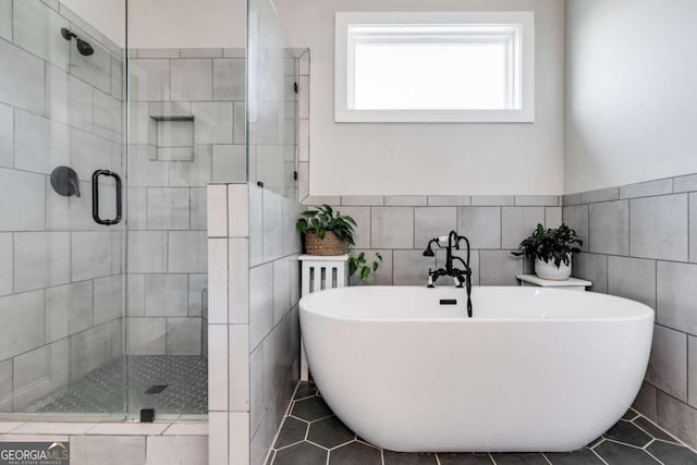 bathroom featuring independent shower and bath, tile walls, and tile patterned flooring