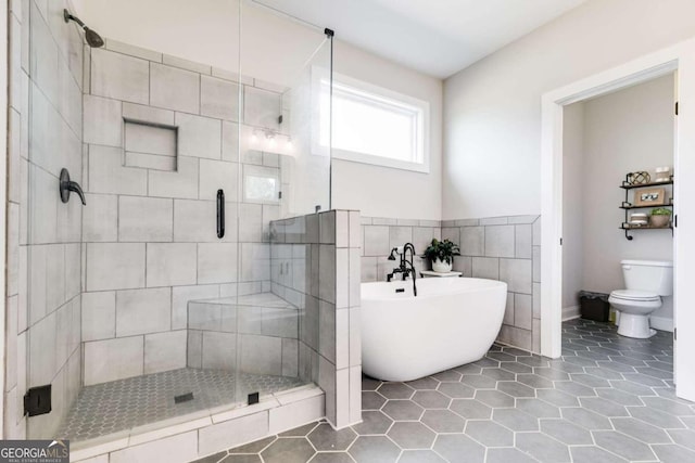 bathroom featuring toilet, tile patterned floors, shower with separate bathtub, and tile walls