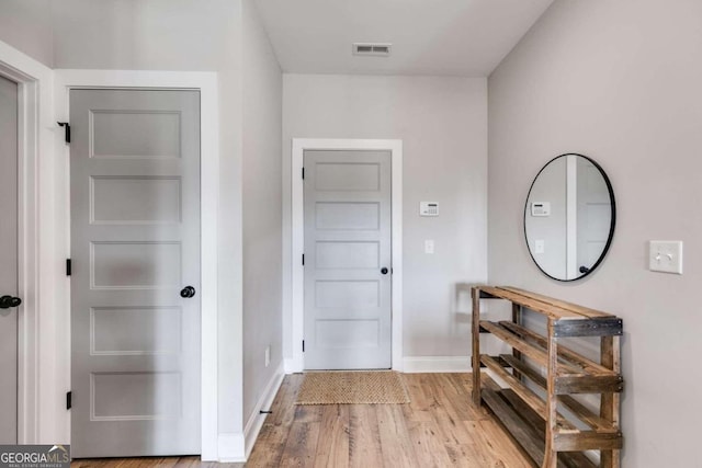 corridor with light hardwood / wood-style floors