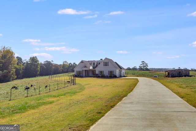 view of front facade with a front yard and a rural view