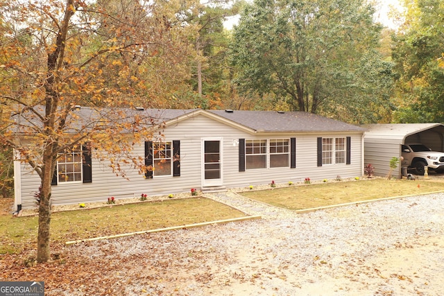 ranch-style house featuring a carport and a front lawn