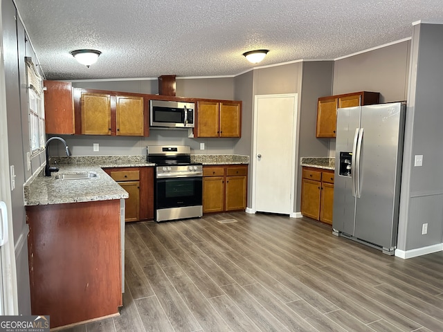 kitchen with dark wood-type flooring, ornamental molding, sink, appliances with stainless steel finishes, and a textured ceiling