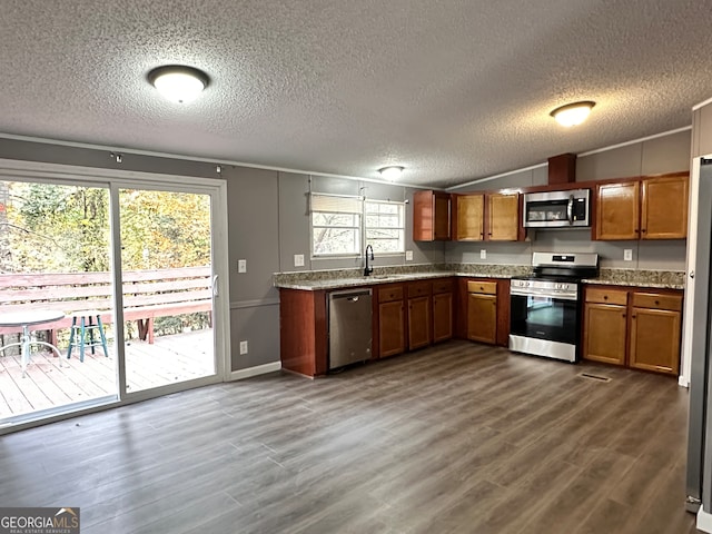 kitchen featuring a healthy amount of sunlight, appliances with stainless steel finishes, a textured ceiling, and dark hardwood / wood-style floors