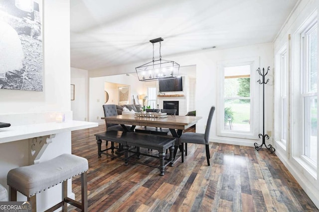 dining space featuring dark hardwood / wood-style flooring and an inviting chandelier