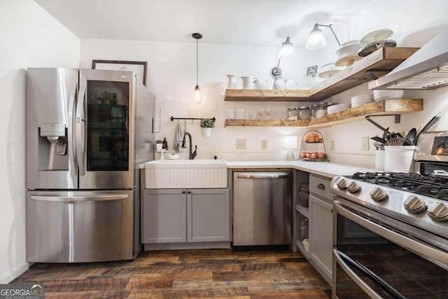 kitchen featuring appliances with stainless steel finishes, dark hardwood / wood-style floors, pendant lighting, gray cabinetry, and sink