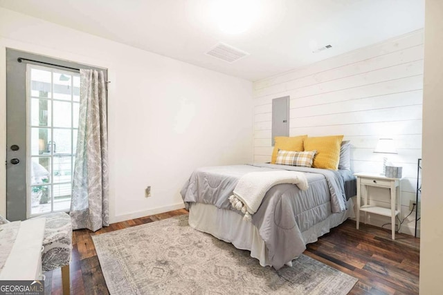 bedroom featuring dark hardwood / wood-style floors and wood walls