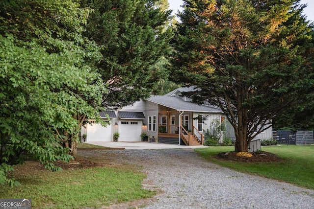 view of property hidden behind natural elements featuring a front lawn and a porch