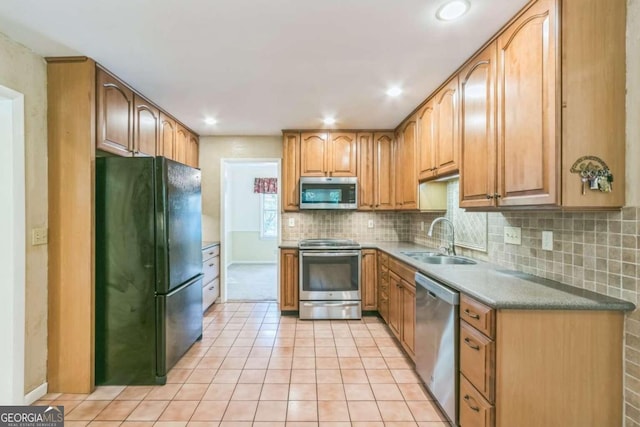 kitchen with sink, stainless steel appliances, light tile patterned floors, and tasteful backsplash