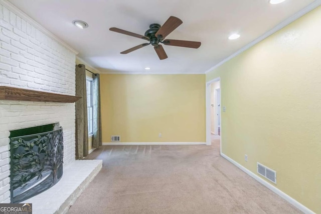 unfurnished living room with ornamental molding, ceiling fan, a fireplace, and light colored carpet