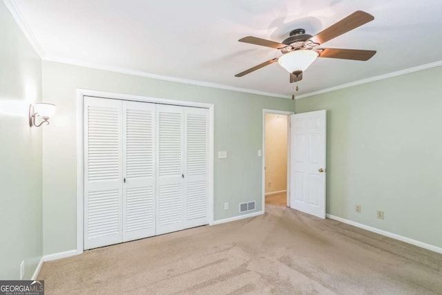 unfurnished bedroom with a closet, ceiling fan, crown molding, and light carpet