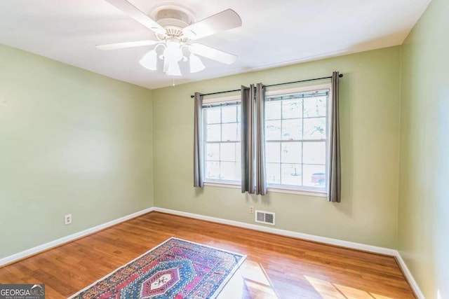 spare room with light wood-type flooring and ceiling fan