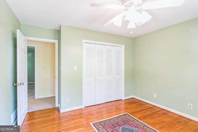 unfurnished bedroom featuring light wood-type flooring, a closet, and ceiling fan