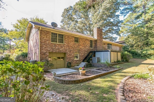 back of property featuring a yard, a deck, and a garage