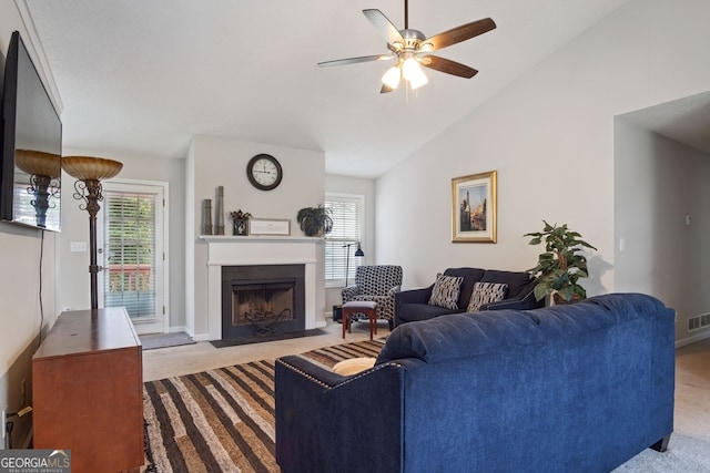 living room featuring lofted ceiling, ceiling fan, light colored carpet, and plenty of natural light