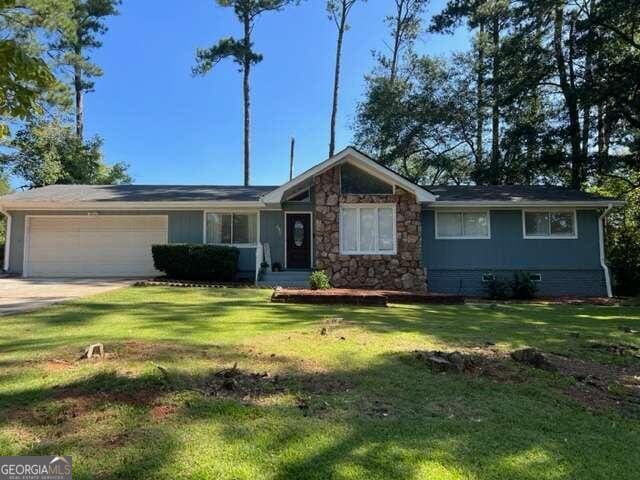 single story home with a front lawn and a garage