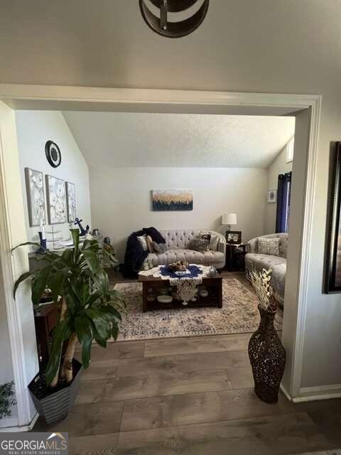 interior space with lofted ceiling and dark hardwood / wood-style flooring