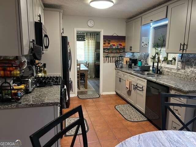 kitchen with sink, appliances with stainless steel finishes, decorative backsplash, and stone countertops