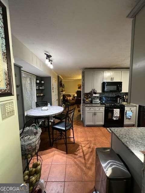 kitchen featuring black appliances, gray cabinetry, and light tile patterned floors