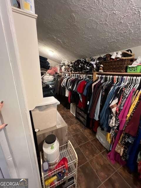 spacious closet featuring dark tile patterned floors