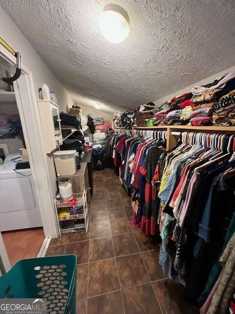 spacious closet featuring independent washer and dryer and dark tile patterned flooring