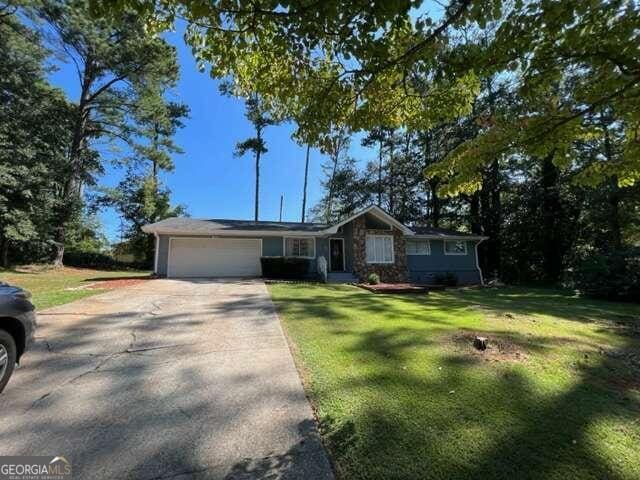 ranch-style house with a garage and a front lawn