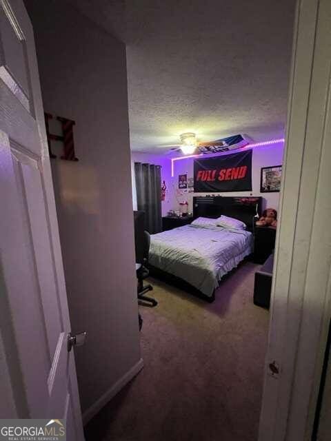 bedroom featuring a textured ceiling and carpet flooring