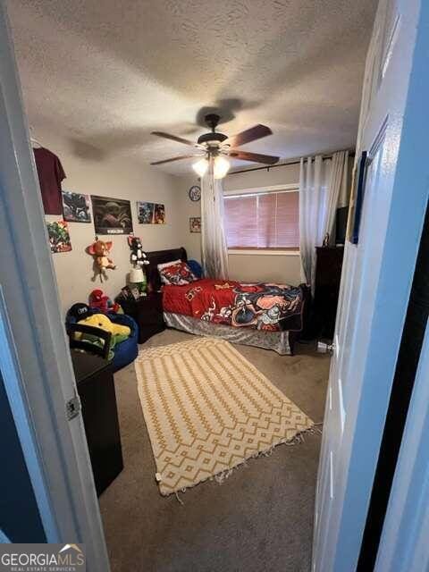 carpeted bedroom with a textured ceiling and ceiling fan