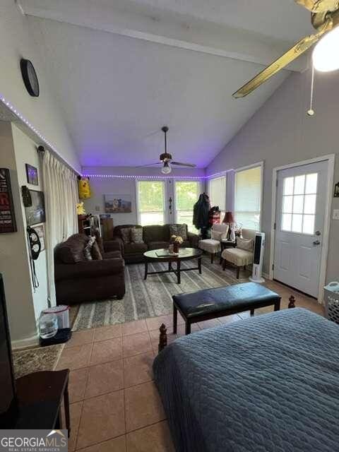 bedroom with ceiling fan, high vaulted ceiling, multiple windows, and tile patterned flooring