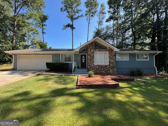 ranch-style home featuring a garage and a front lawn