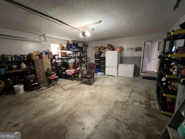 garage featuring a garage door opener and white fridge