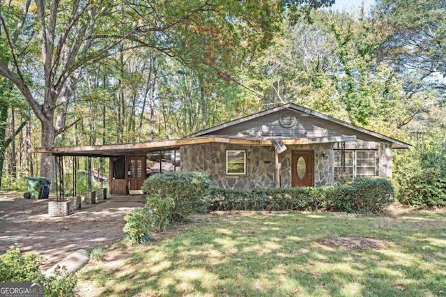 ranch-style house featuring a front lawn and a carport