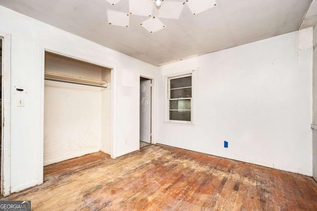 unfurnished bedroom featuring wood-type flooring and a closet