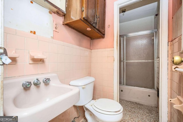 bathroom with tile walls, toilet, and walk in shower